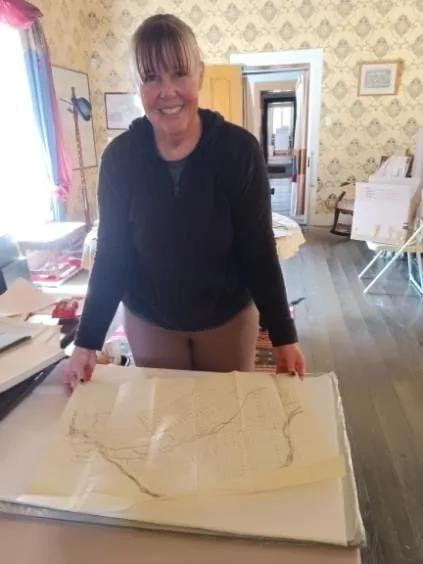 Machelle Wood examining an open archival volume