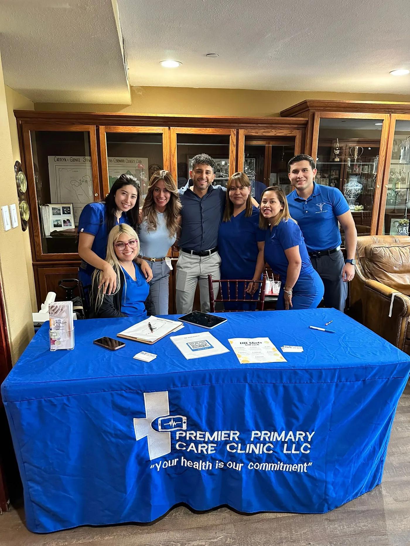Group behind a Premier Primary Care Clinic table at a community event
